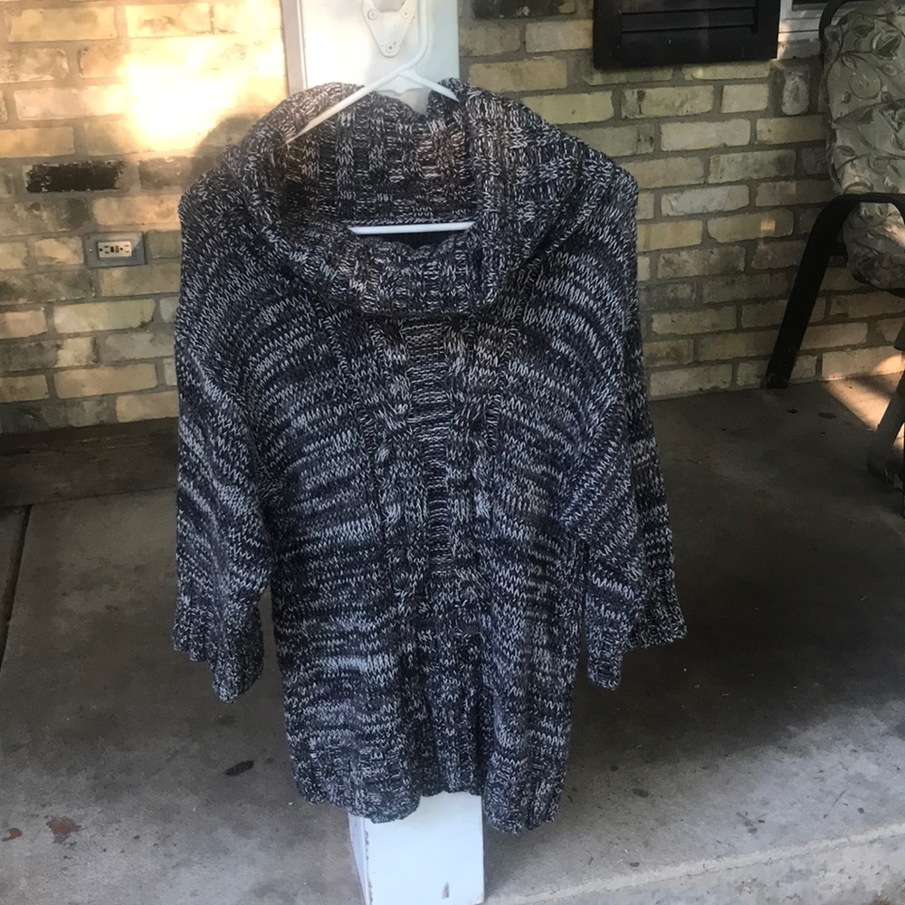 Black and white sweater with large neck and wide sleeves.
